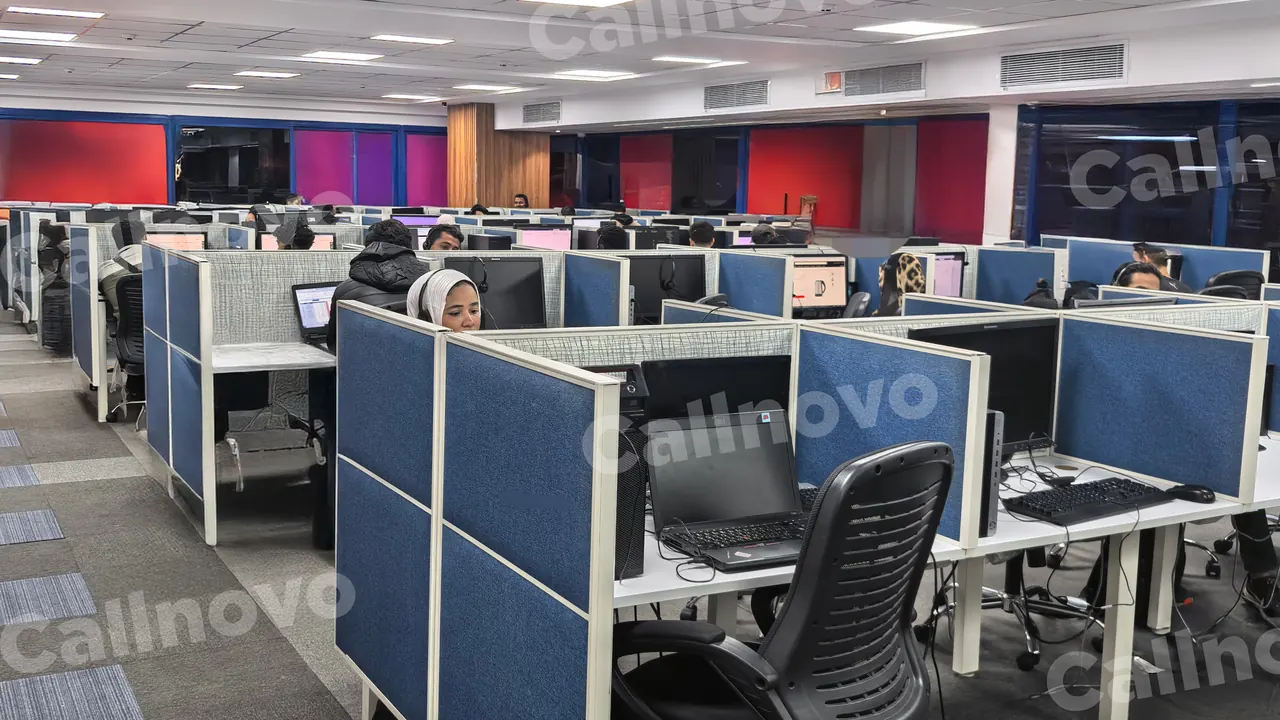 A wide view of a Callnovo contact center floor with rows of blue-partitioned workstations