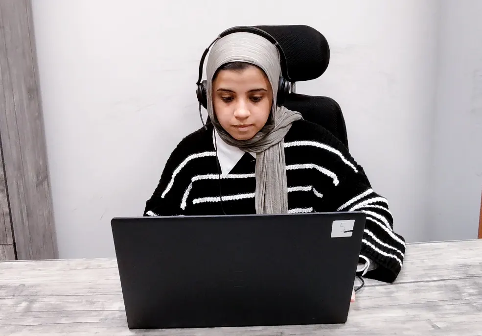 A Callnovo.ai human agent wearing a headset works on a laptop at a plain desk in a bright office
