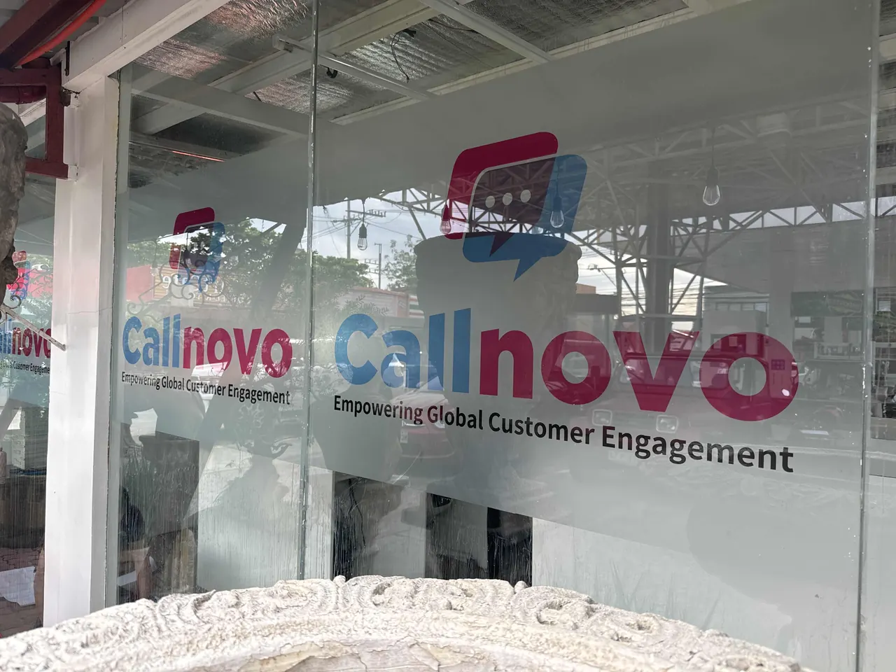 The Callnovo logo on the glass entrance of a contact center