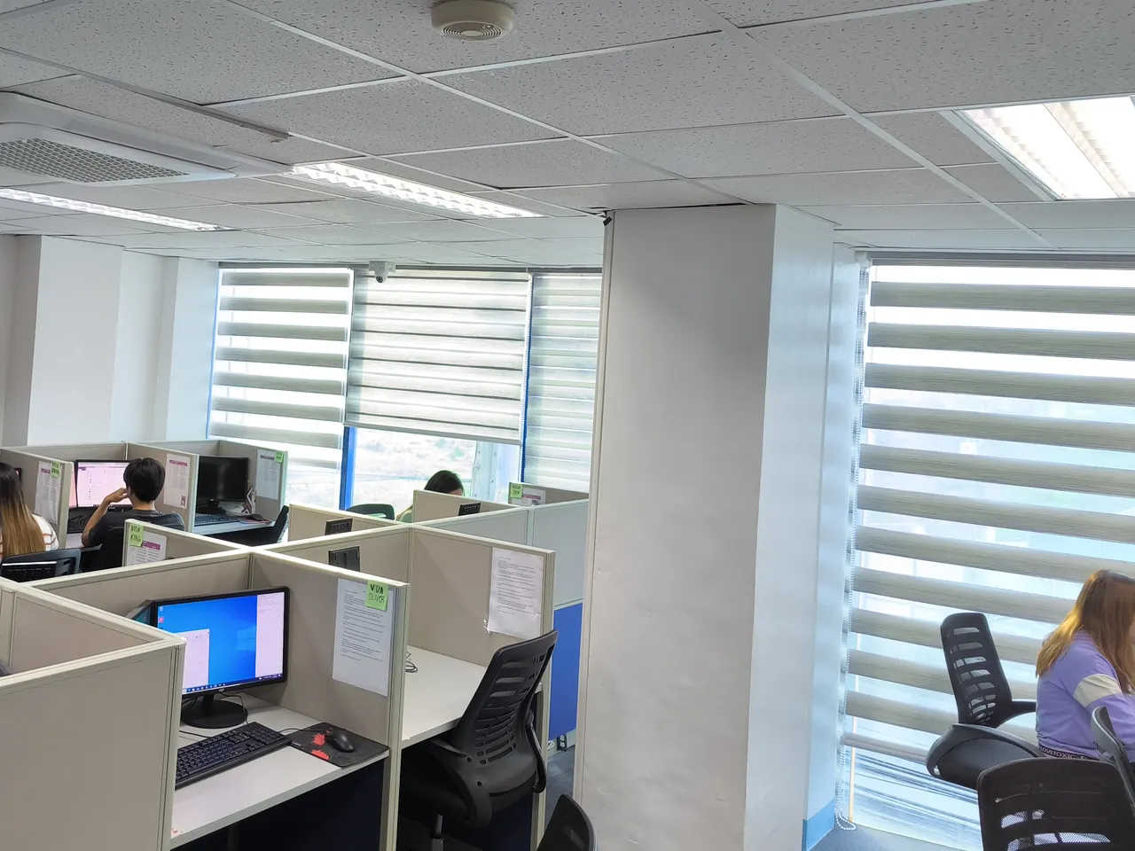 A Callnovo contact center floor with agents working at partitioned desks by the windows