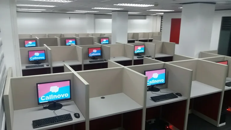 Partitioned computer workstations with Callnovo branding on the screens.