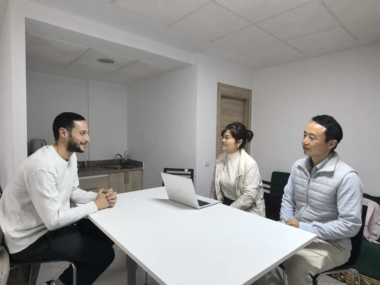 Three people talking around a table in a Callnovo office.